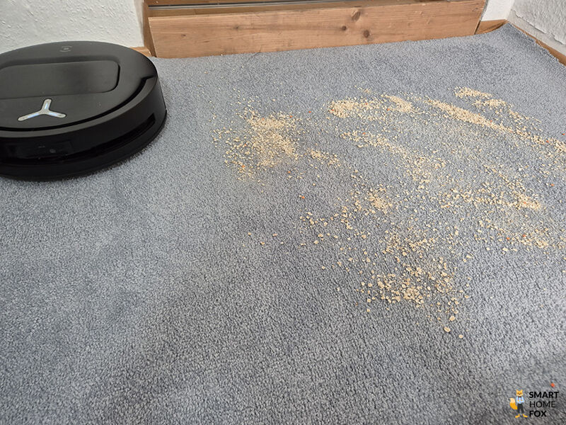 Der ECOVACS DEEBOT T80 OMNI saugt Schmutz auf Teppichboden auf.